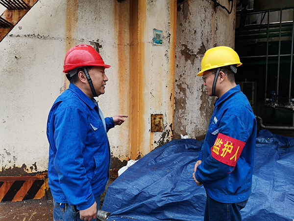 3月31日上午，在一期鍋爐舊脫硫塔底部清理現(xiàn)場(chǎng)，安全員焦路秦對(duì)監(jiān)護(hù)人岳維哲的提問(wèn)。.jpg